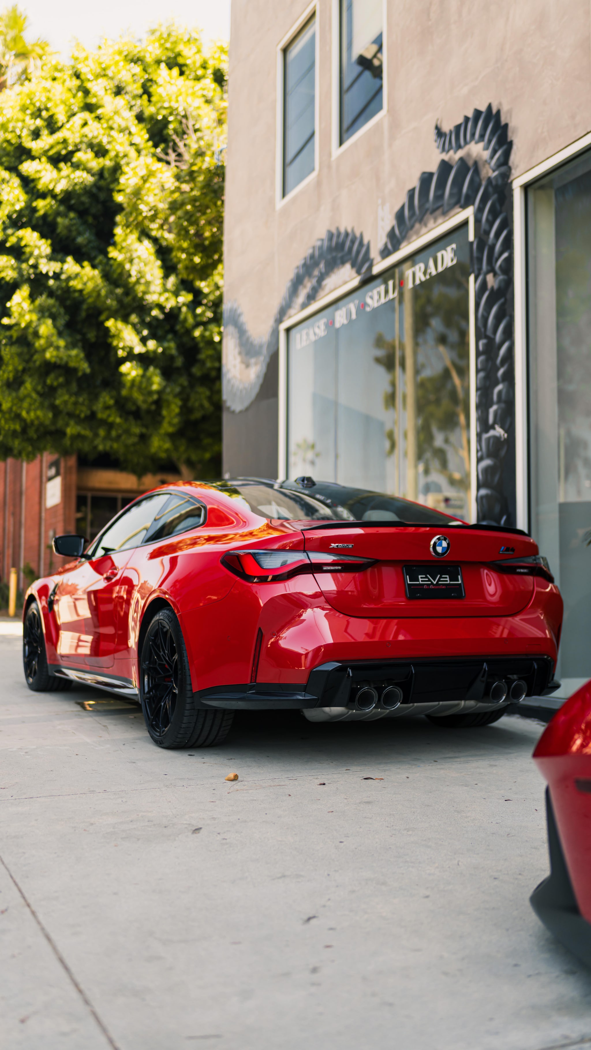 Red BMW M4 parked outside LEVEL