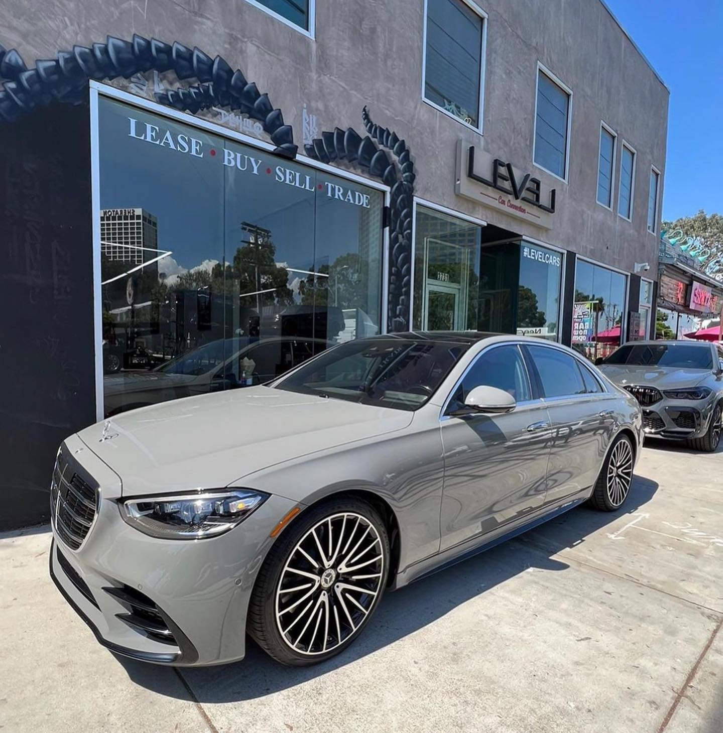 Grey Mercedes-Benz S-Class in front of the LEVEL storefront