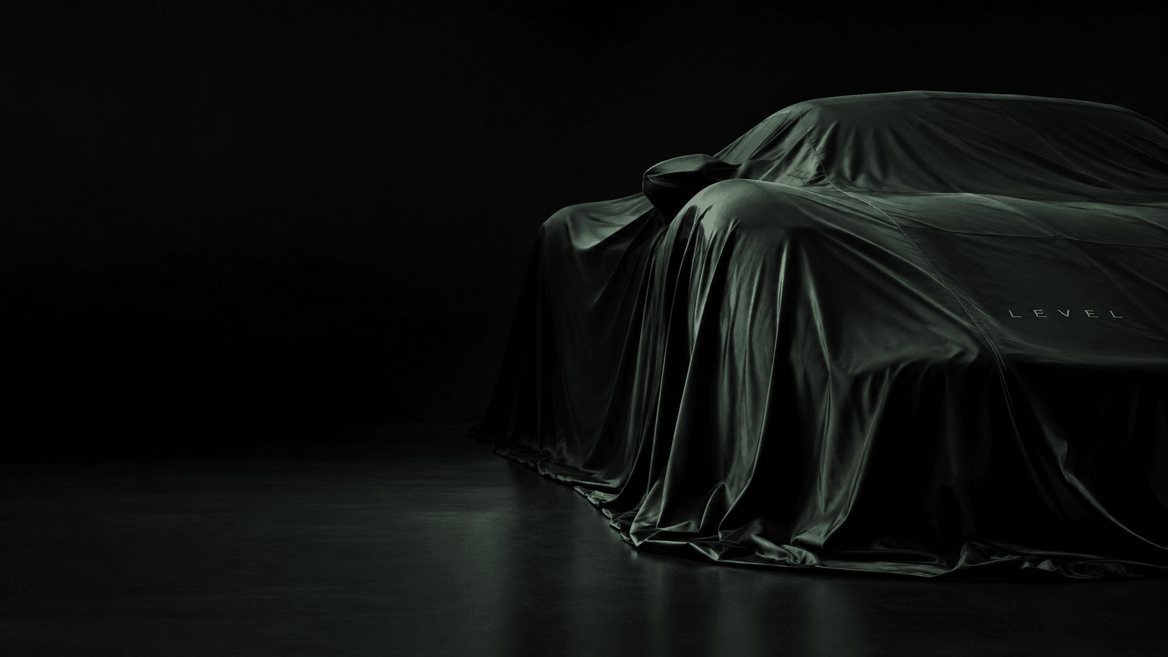 A sports car under a dark green LEVEL cover