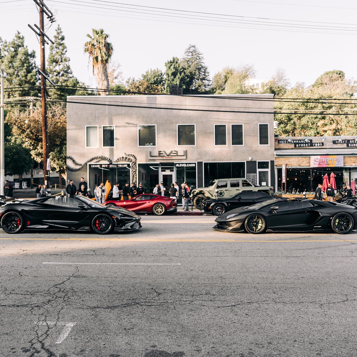 A black McLaren and Lamborghini on the street outside the LEVEL building